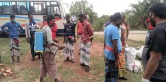 গ্রামে ঢুকতেই ধান কাটা শ্রমিকদের গায়ে জীবানুনাশক স্প্রে